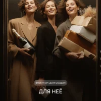 Три улыбающиеся женщины в элегантных пальто с шампанским и подарочными коробками в лифте — рекламный образ аромата Breath of Lelya для неё